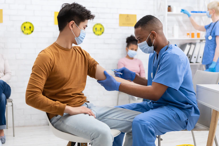 A health-care worker giving an injection to a young adult