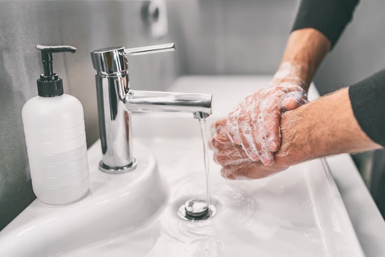 A man washes hands.