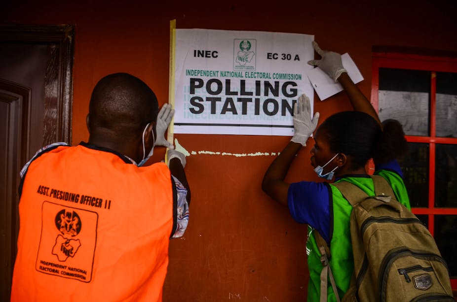 Polling station workers adding posters on the wall at polling unit 26, ward 5, Iguododo, Orhionmwon Local Government Area, in Edo State, on September 19 , 2020.