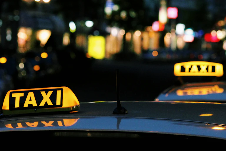 Two taxis on a street at night