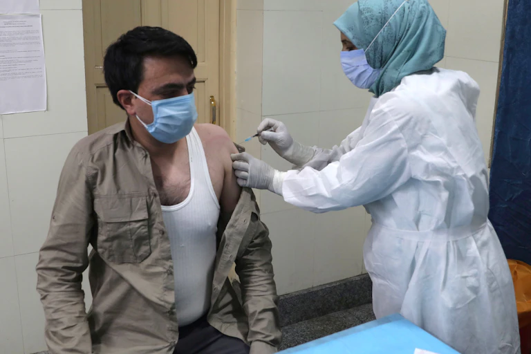 A man in India being vaccinated by a nurse