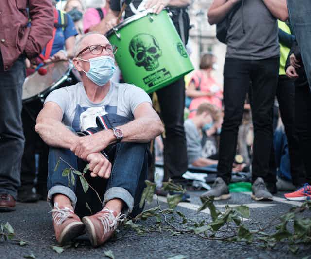 A protestor sits on the ground.