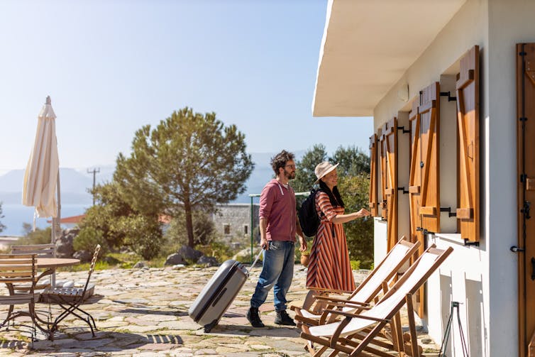 A couple approach a holiday house.