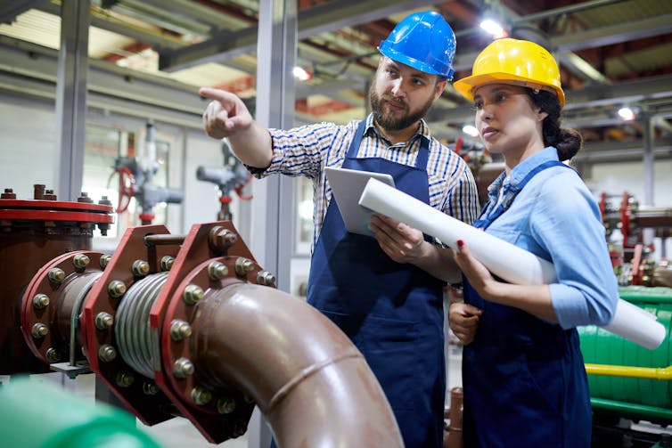 male engineer points as female look on