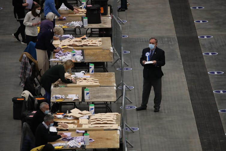 Ballots being counted while Alex Salmond watches on.