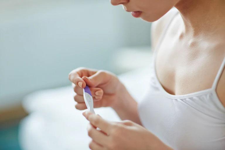 A woman looks at a pregnancy test.