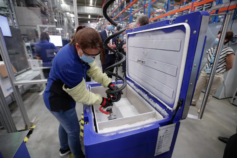 A worker in a vaccine manufacture plant packs doses.