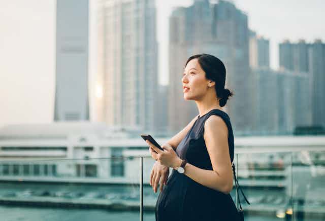 pregnant woman outdoors holding phone