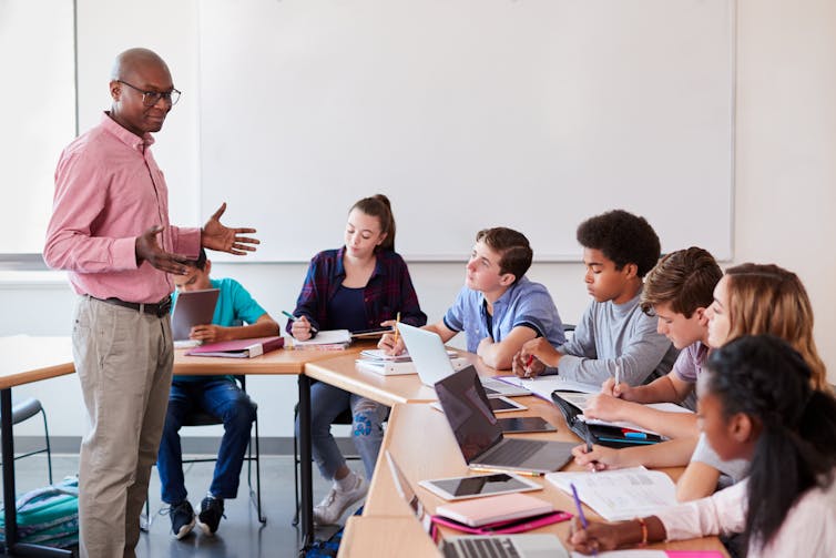 A teacher stands in front of a class of students.