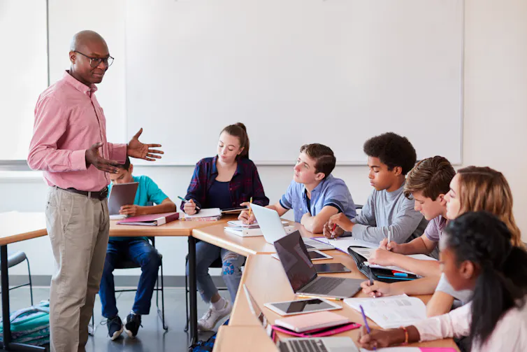 A teacher stands in front of a class of students.