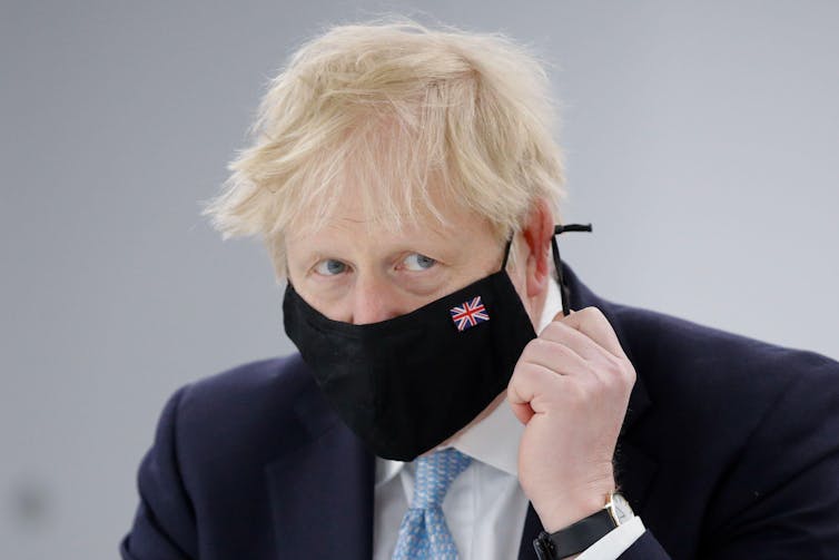 Boris Johnson wearing a face mask with a union flag embroidered onto it.