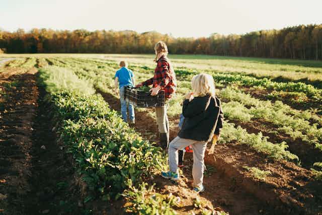 Kat Becker and two of her children in the field.
