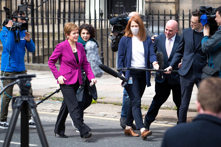 Nicola Sturgeon walks down an Edinburgh Street as she talks to the press.