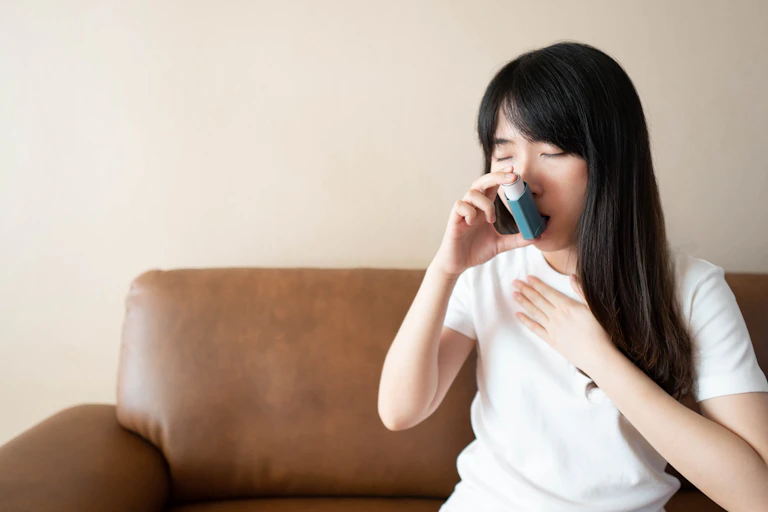 Person using asthma inhaler