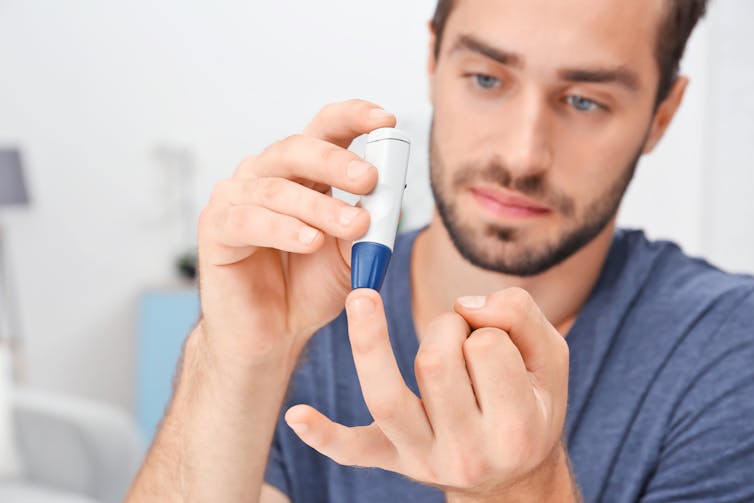 Person with diabetes using a lancet pen