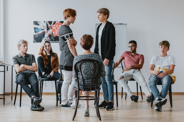 Several young people take part in a group session.