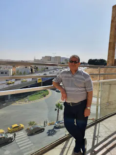 Un homme pose pour une photo dans une ville