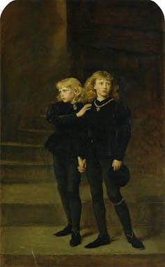 Two young boys dressed in black stand in a tower.