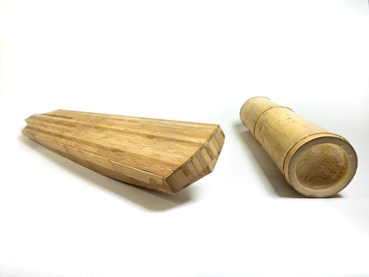 A cricket bat next to a section of bamboo