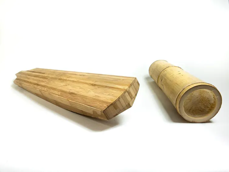 A cricket bat next to a section of bamboo