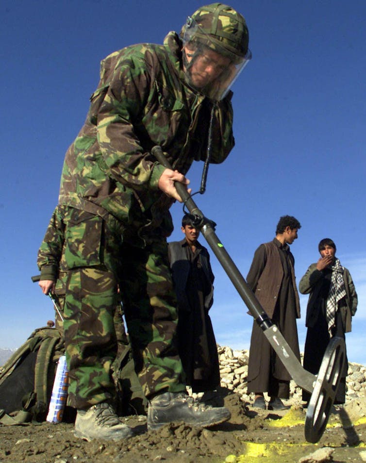 Soldier holding a metal detector.