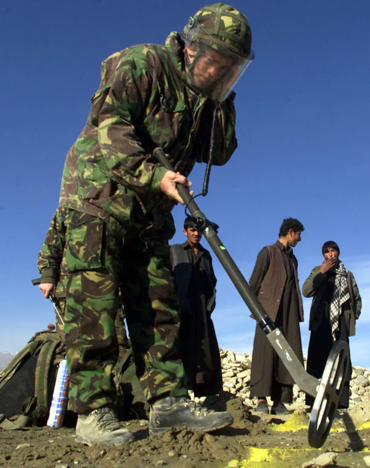 Soldier holding a metal detector.