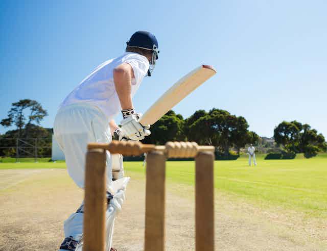 A batsman preparing to take a shot, photographed from behind the stumps