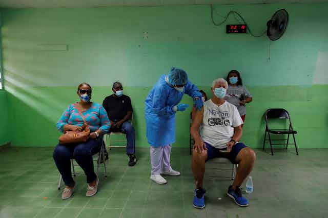 A man receives the second dose of the Pfizer vaccine against covid-19, at the Republica de Colombia school, in San Miguelito, Panama