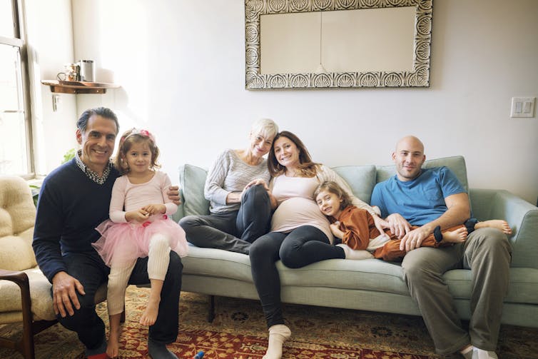 family portrait of multiple generations with pregnant woman in the center