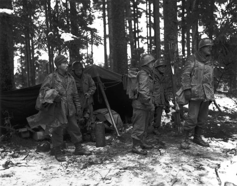 Des soldats américains d'origine japonaise se tiennent dans une forêt française