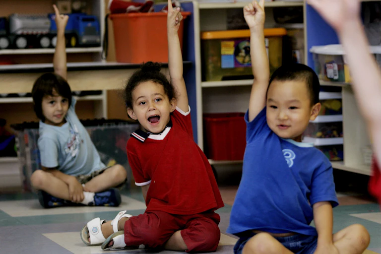Children with their hands raised.