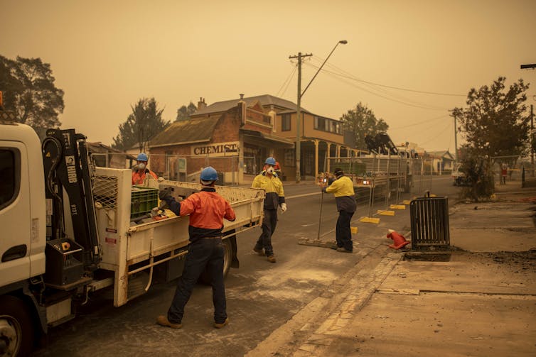 People help erect fences in a bushfire-affected town.