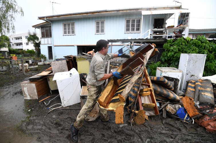 Members of a flood-affected community clean up.