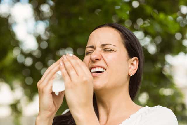 Person sneezing outdoors