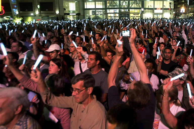 A crowd of people holding flameless candles