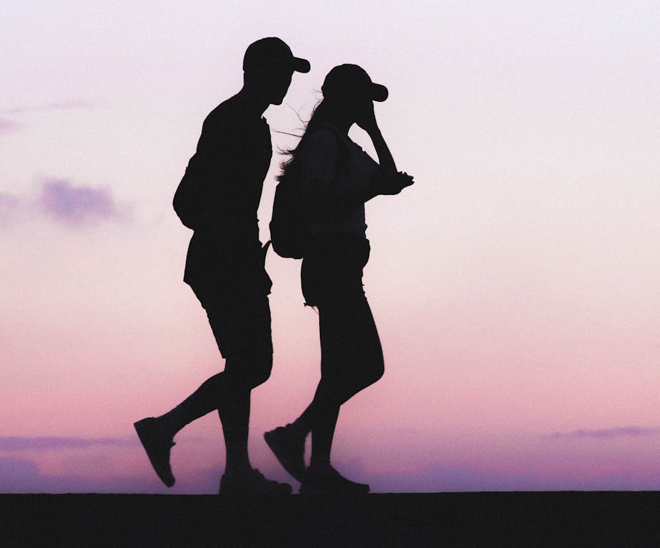 Silhouettes of man and woman walking at twilight