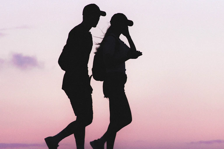 Silhouettes of man and woman walking at twilight