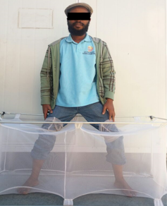 Man sitting with his feet in a cage