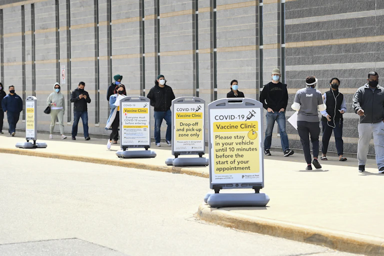 People stand in line up at a mass vaccination clinic.