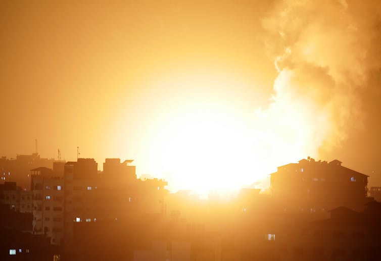 Flammes et fumée dans le ciel de la ville de Gaza suite aux frappes aériennes lancées par les forces de défense israéliennes, le 10 mai 2021