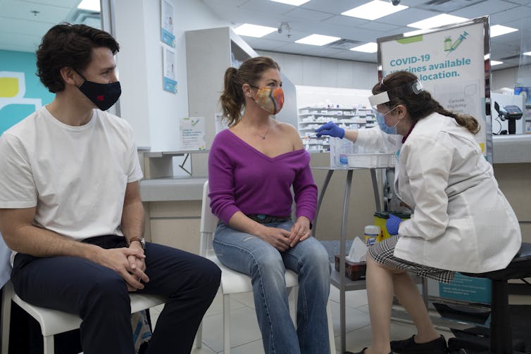 Sophie Grégoire Trudeau gets her AstraZeneca vaccination as Justin Trudeau looks on.