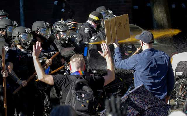 Seattle police officers deploy pepper spray.