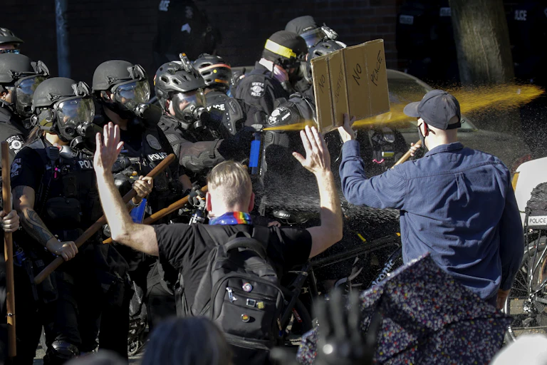 Seattle police officers deploy pepper spray.