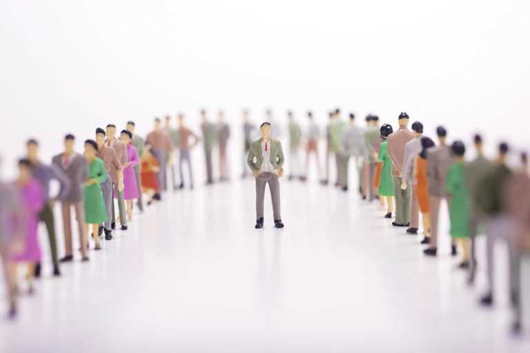 A figurine enveloped in a line of other figurines