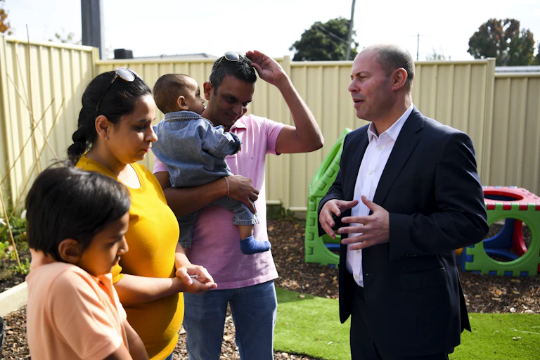 Josh Frydenberg talks to a family at a childcare centre.