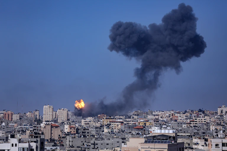 Skyline of Gaza City showing a tower block on fire.