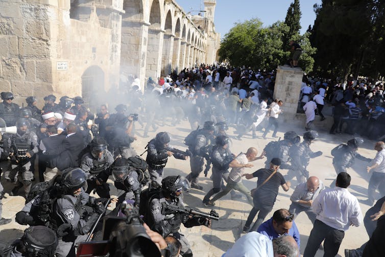 Israeli security forces fire sound grenades inside the al-Aqsa Mosque compound in the Old City of Jerusalem