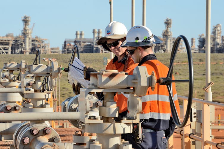 two men stand over equipment