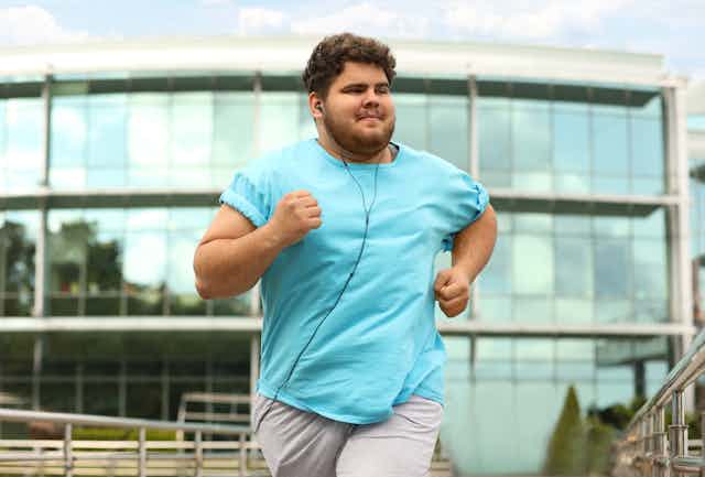 An obese man jogging