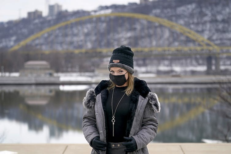 A woman stands by a river